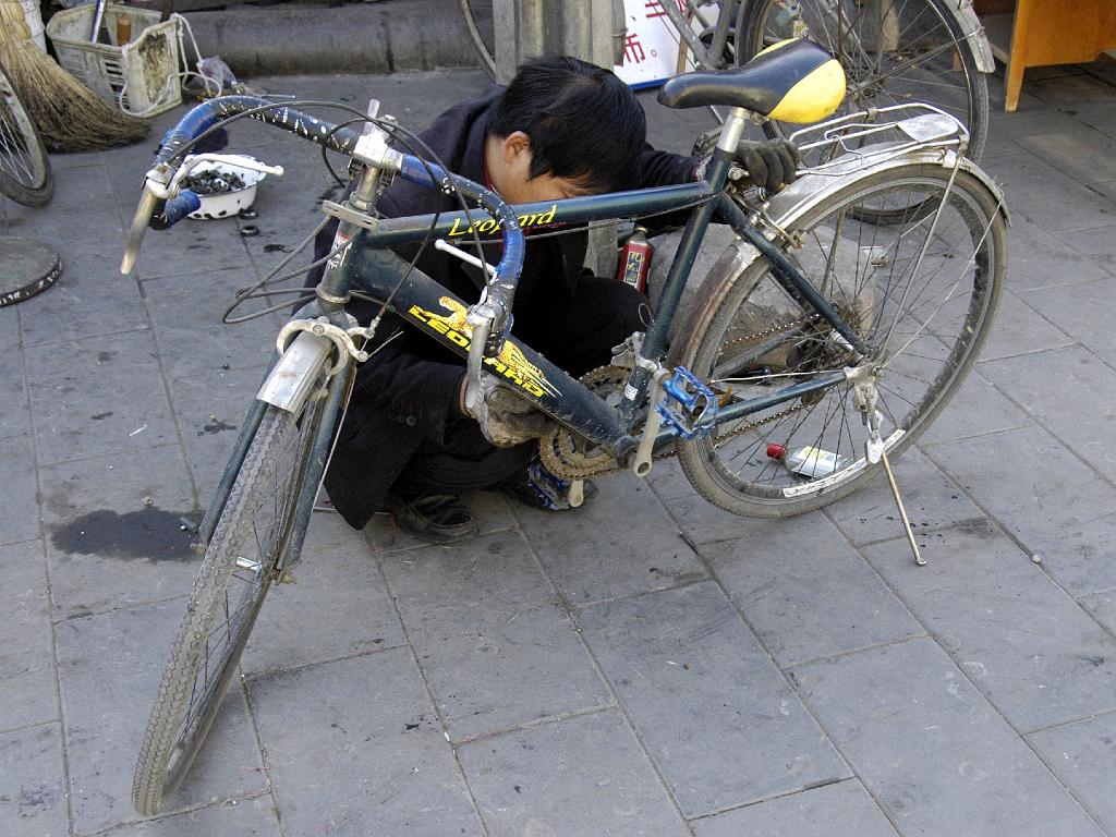 P2007111044.jpg - Beijing. Maar er is in de Hutong nog wel plaats voor een fietsenmaker.